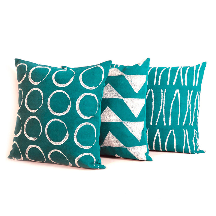 Teal pillow covers with white abstract lines and geometric triangle print