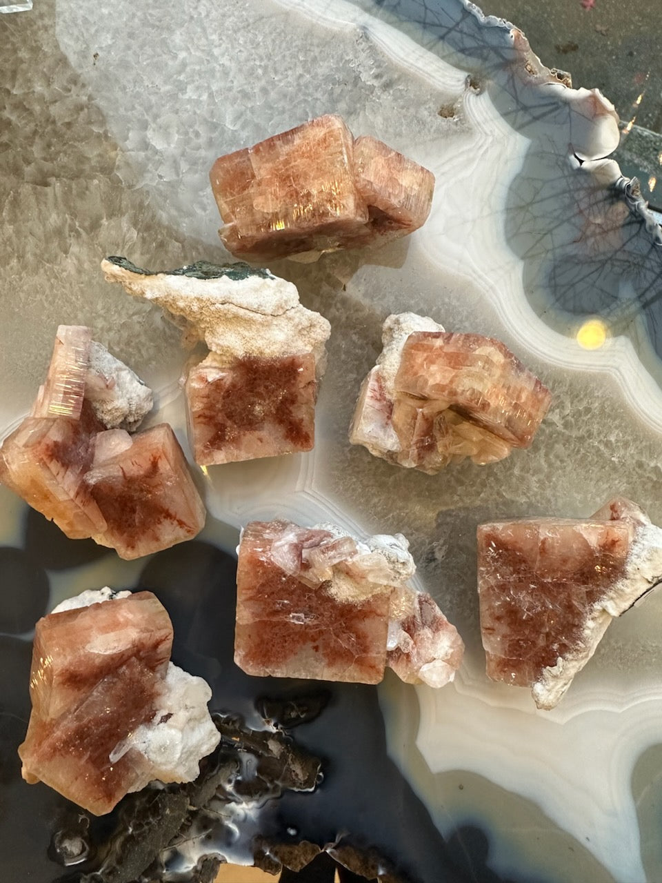 Red apophyllite cube crystal specimen with attached white druzy mineral.