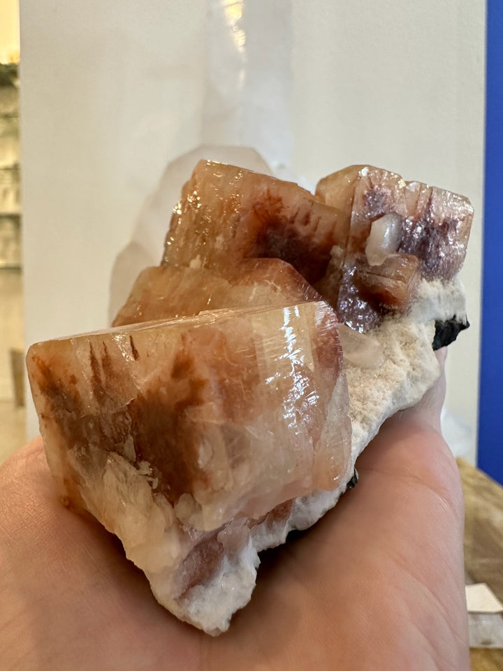 Red-brown apophyllite cubes with stilbite points on white rock matrix, handheld