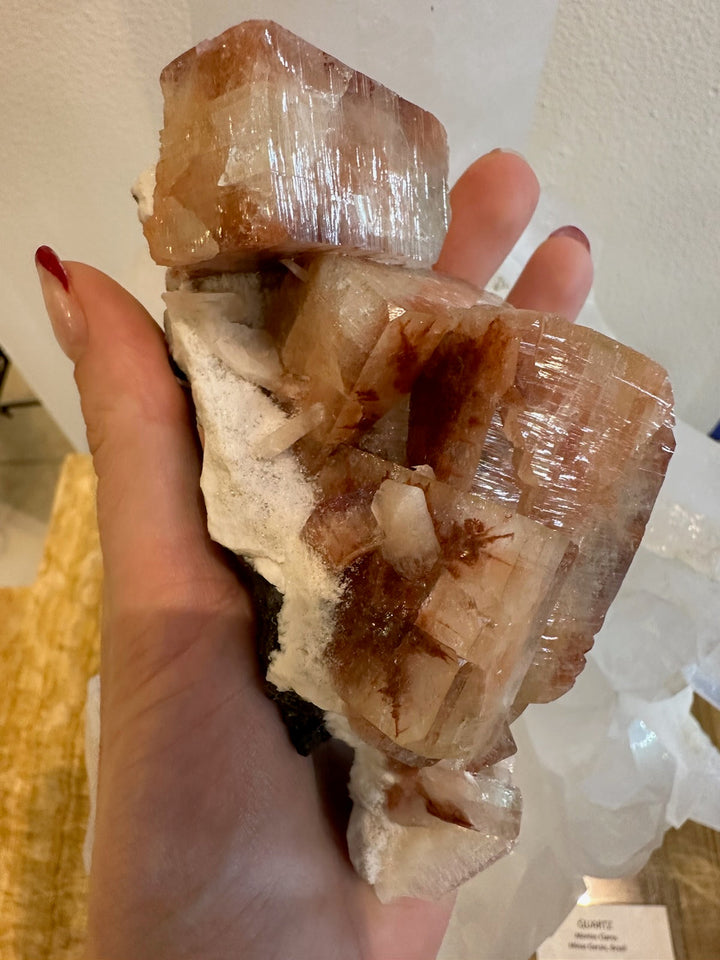 Red apophyllite crystal cluster with translucent cube facets on white matrix