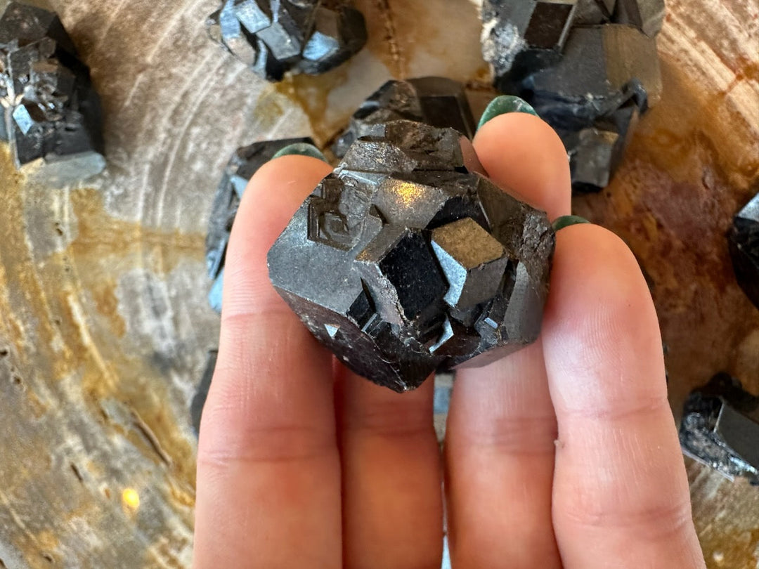 Melanite garnet crystal cluster close-up: rough black cubes with reflective blue highlights