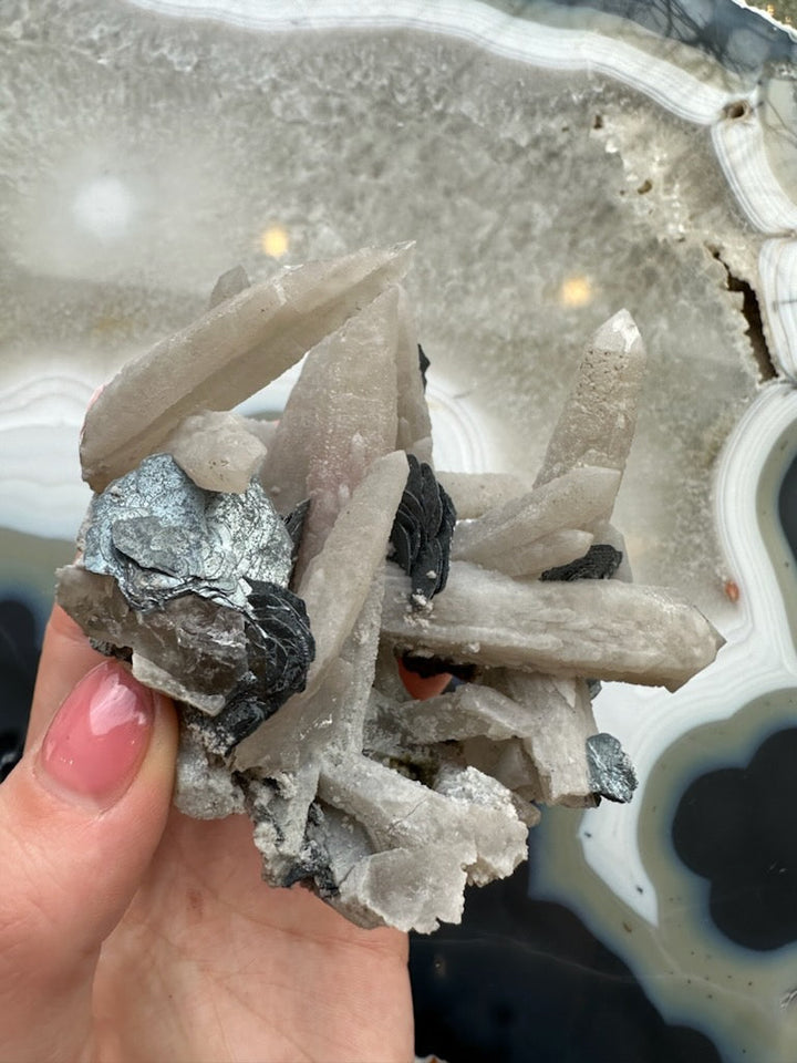 Dogtooth calcite cluster with mica, close-up pale crystal points with dark mica flakes