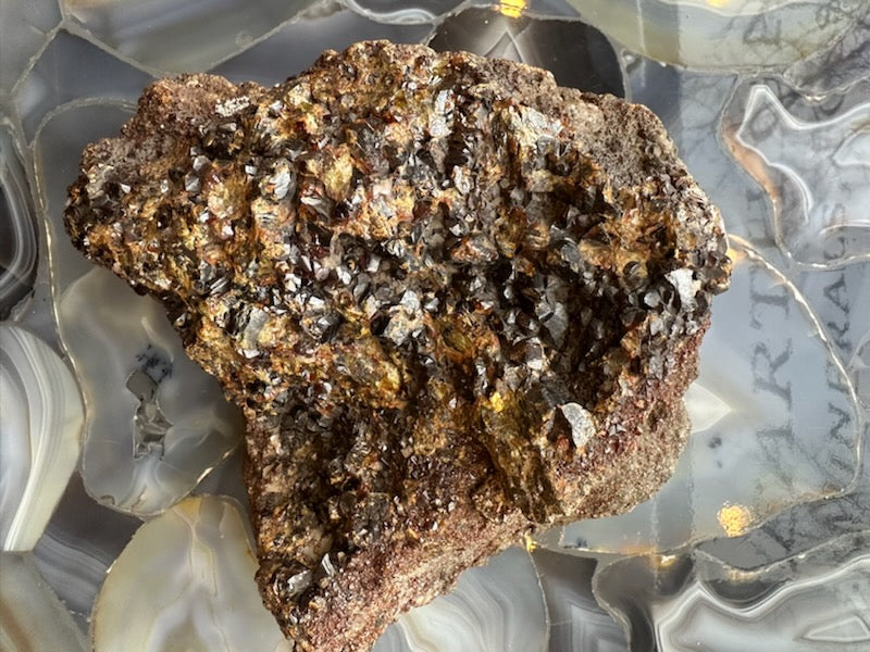 Garnet crystal cluster specimen with chunky rough texture and metallic silver-brown crystals