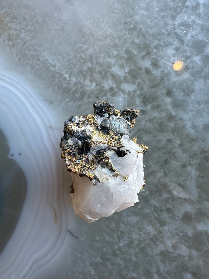 Quartz crystal with golden pyrite cluster mineral specimen on rough rock