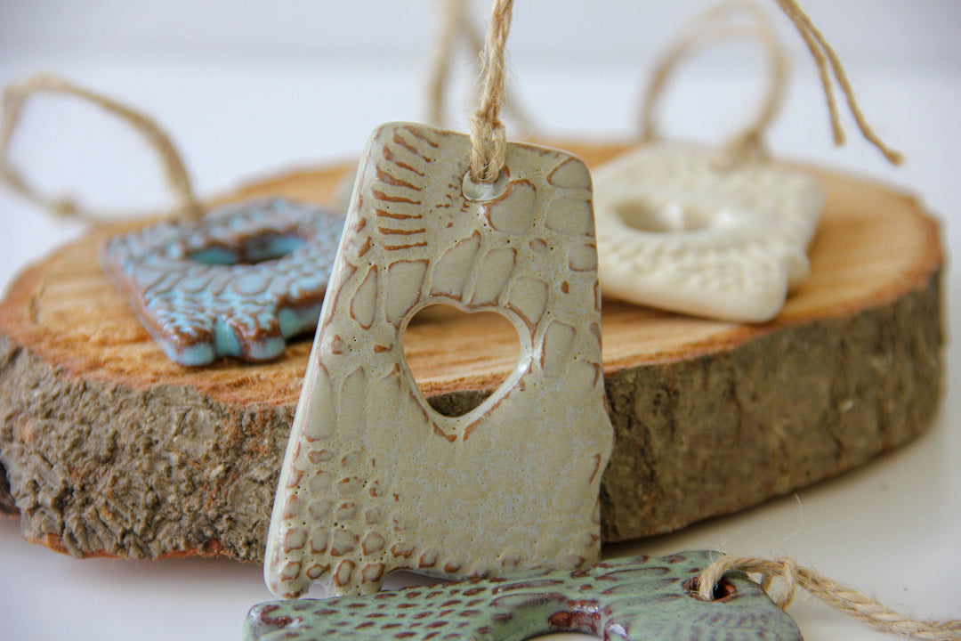 Green letter A ornament with heart cutout and textured glaze, with cream and blue behind