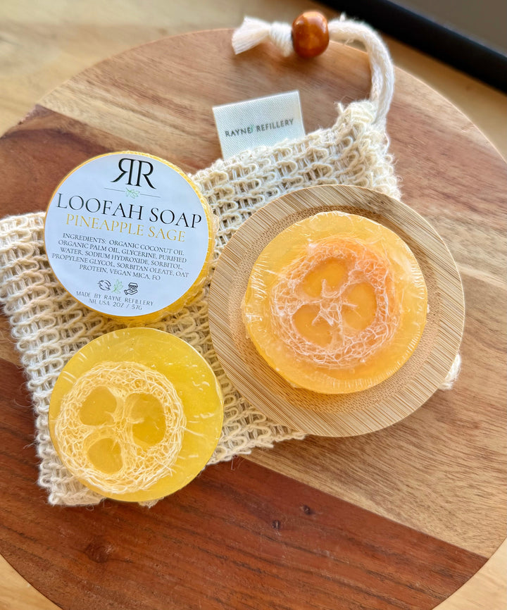 Orange and yellow loofah soap discs with 'Pineapple Sage' scent label on wooden tray