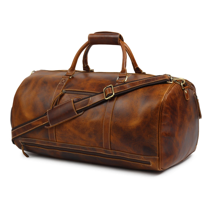 Brown leather duffel bag with crossbody strap and front zipper panel.