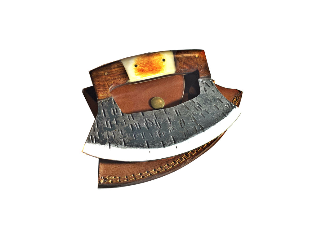 Curved ULU knife with textured blade, wood grip, amber inlay, and leather sheath