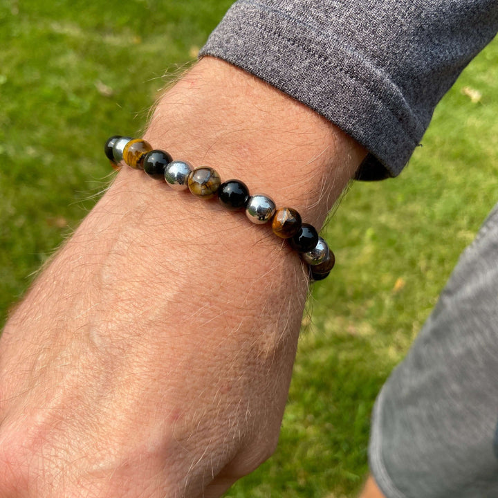 Beaded tiger eye bracelet on wrist with black stones and golden tiger eye accents.