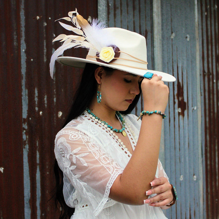Turquoise beaded collar necklace with round gold coin charm worn by a model