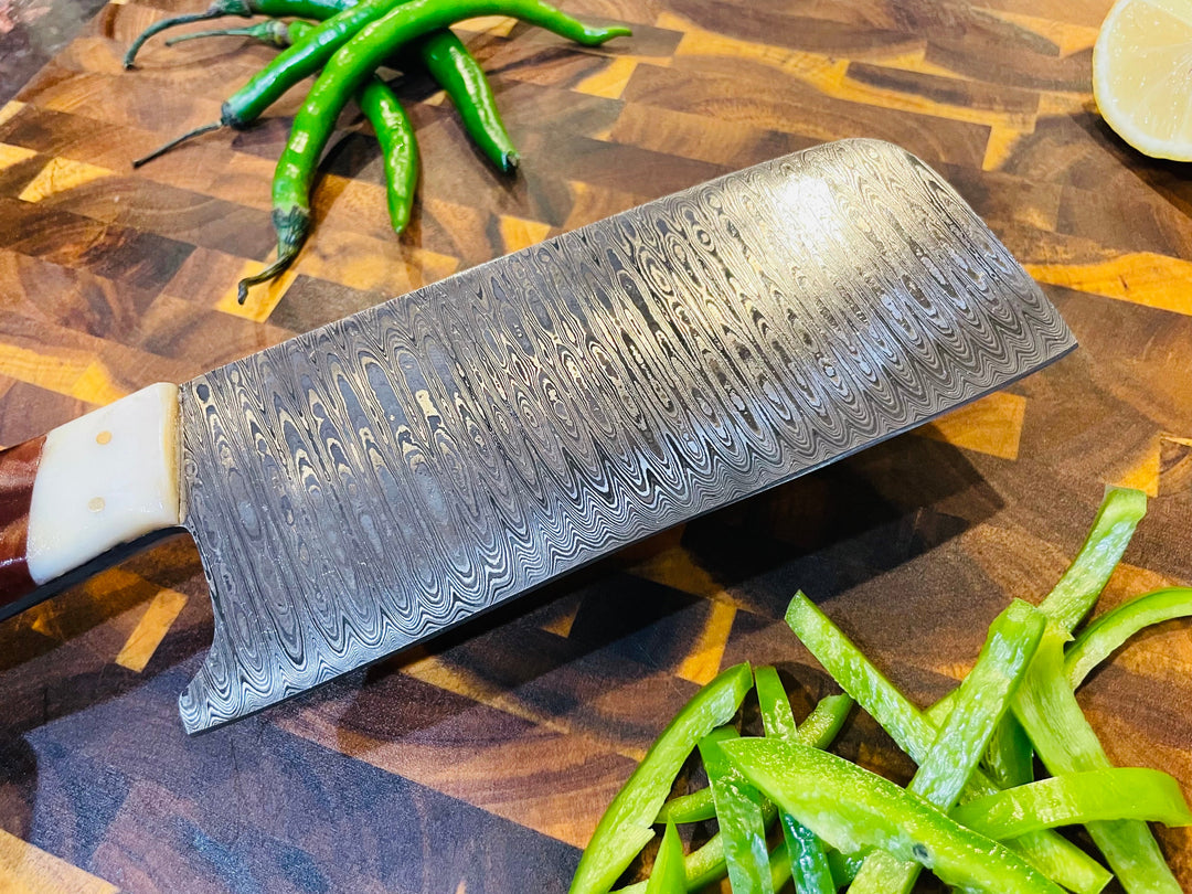 Damascus-style chef knife blade with wavy pattern and wood-and-cream handle