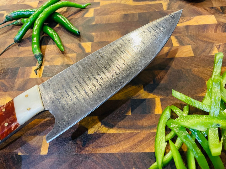 Damascus-style chef knife with straight edge and wood-and-cream handle