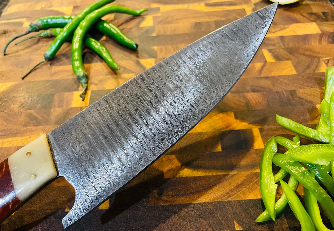 Damascus-style chef knife close-up of blade and wood-and-cream handle