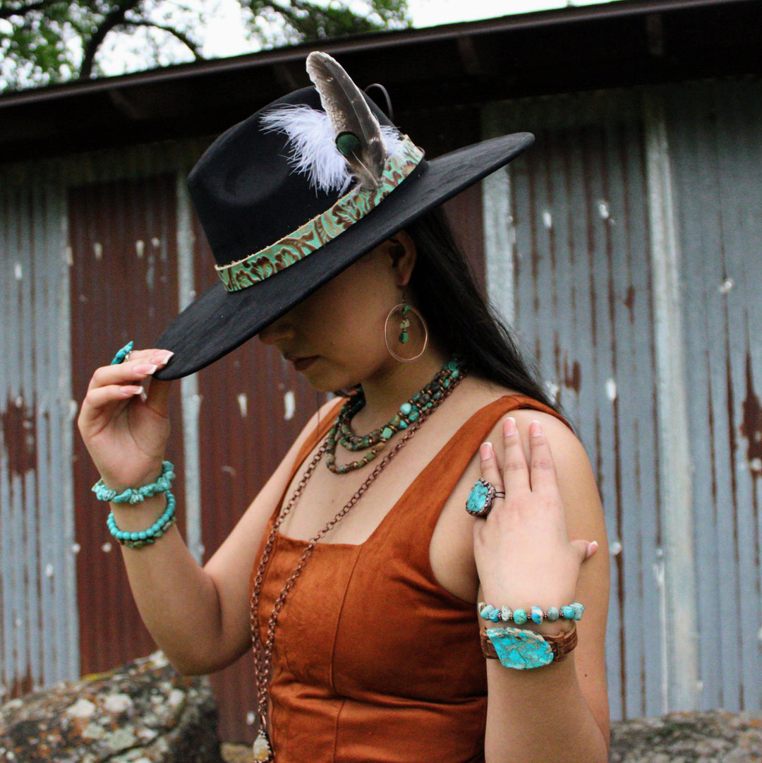 Turquoise beaded stretch bracelet with copper-toned accent beads on wrist