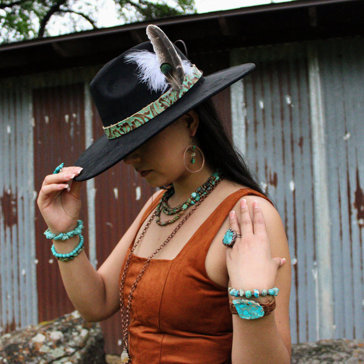 Turquoise beaded stretch bracelet with copper-toned accent beads on wrist
