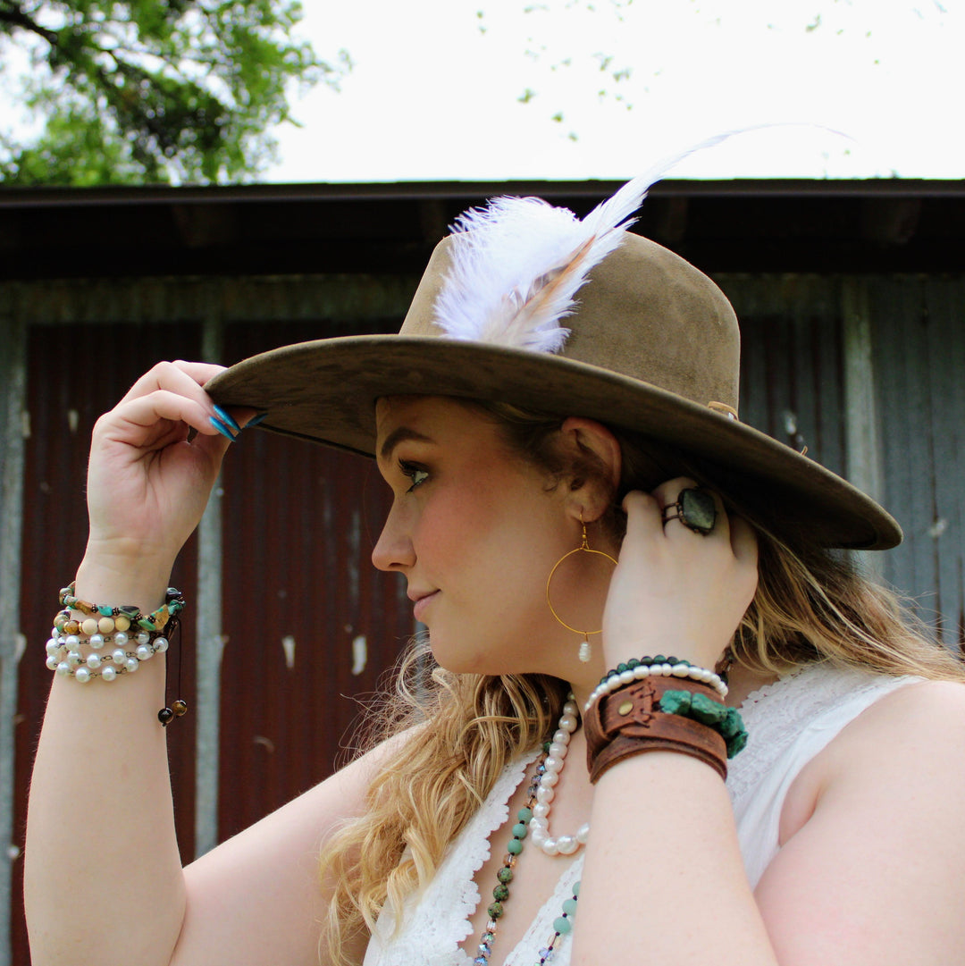 Turquoise beaded wrap bracelet with white and dark brown beads on wrist