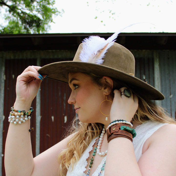 Turquoise beaded wrap bracelet with white and dark brown beads on wrist