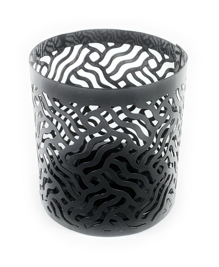 Grey patterned metal votive candle holder with cutout swirl lattice, cylindrical