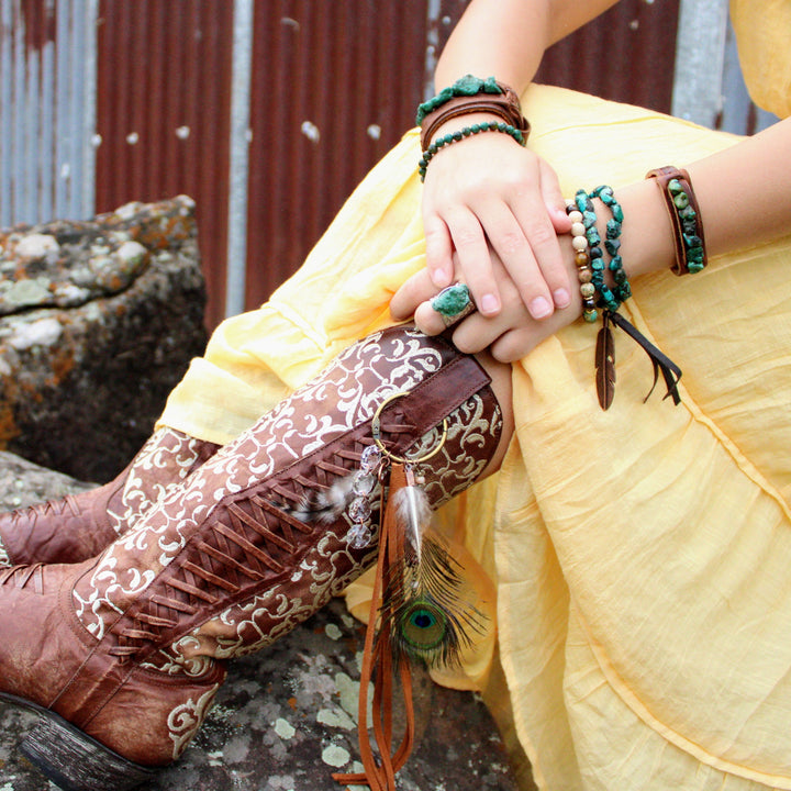 Turquoise and white beaded bracelets with dark brown accents on wrist
