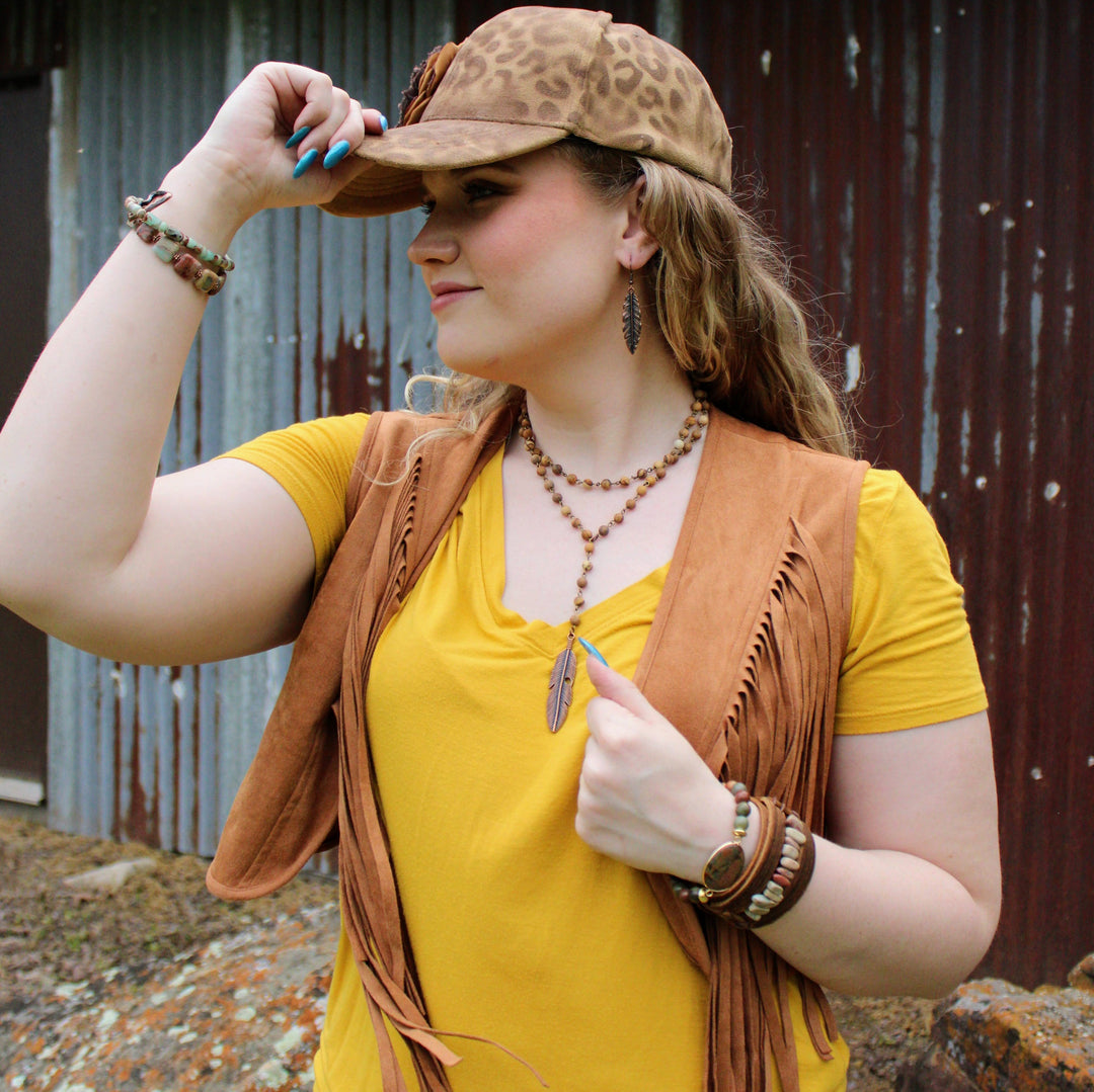 Turquoise and tan beaded bracelet worn on wrist with stacked bracelets and bangles
