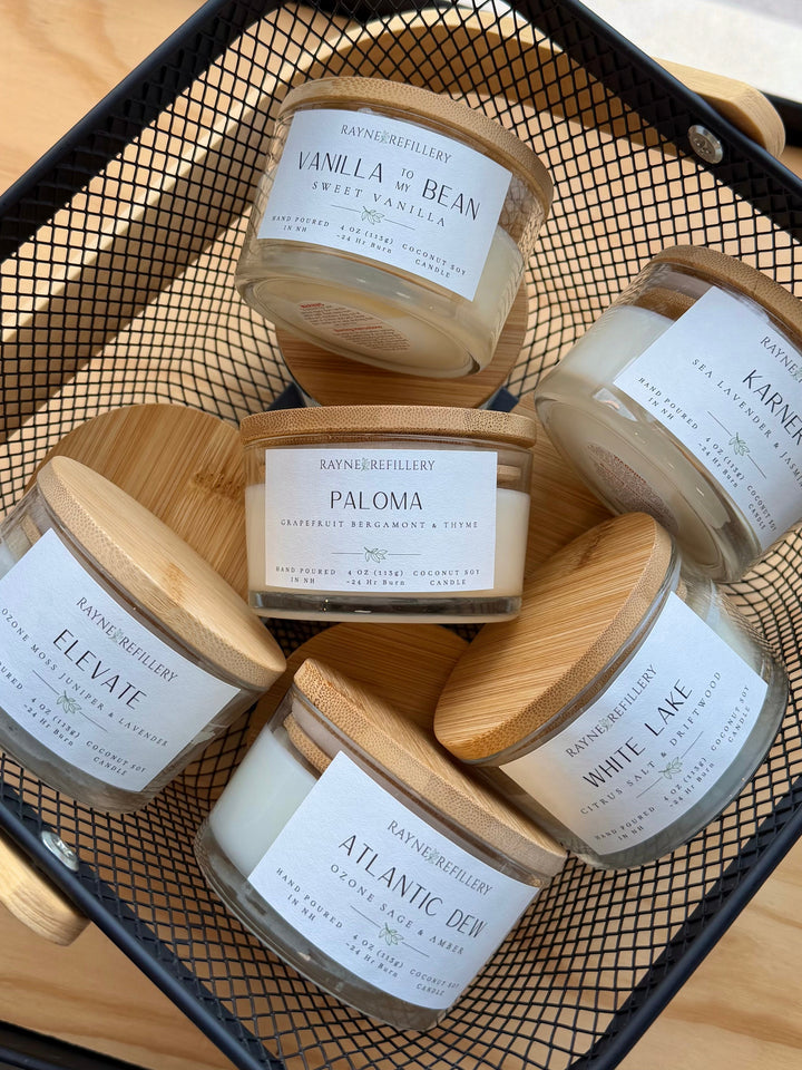 Coconut soy scented candles with white wax jars and cream labels in a wooden tray