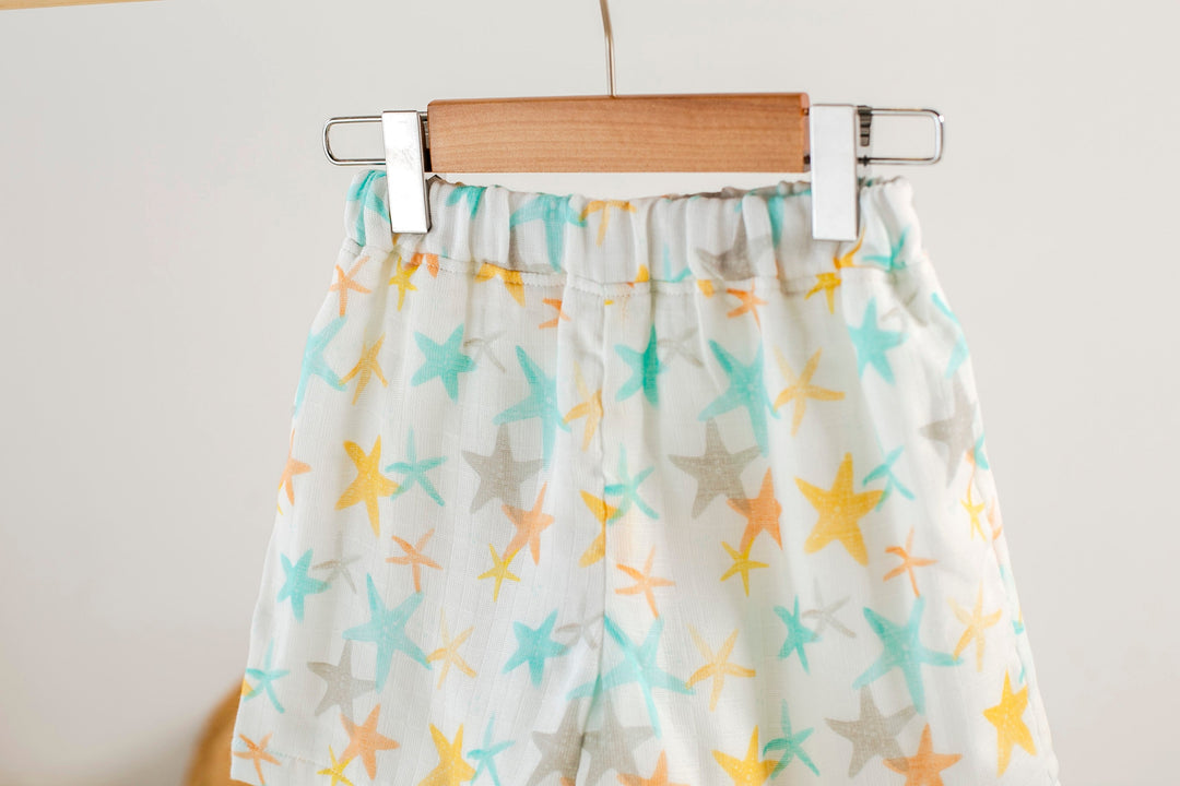Close-up of starfish muslin shorts: elastic waistband with gathered fabric, multicolor print