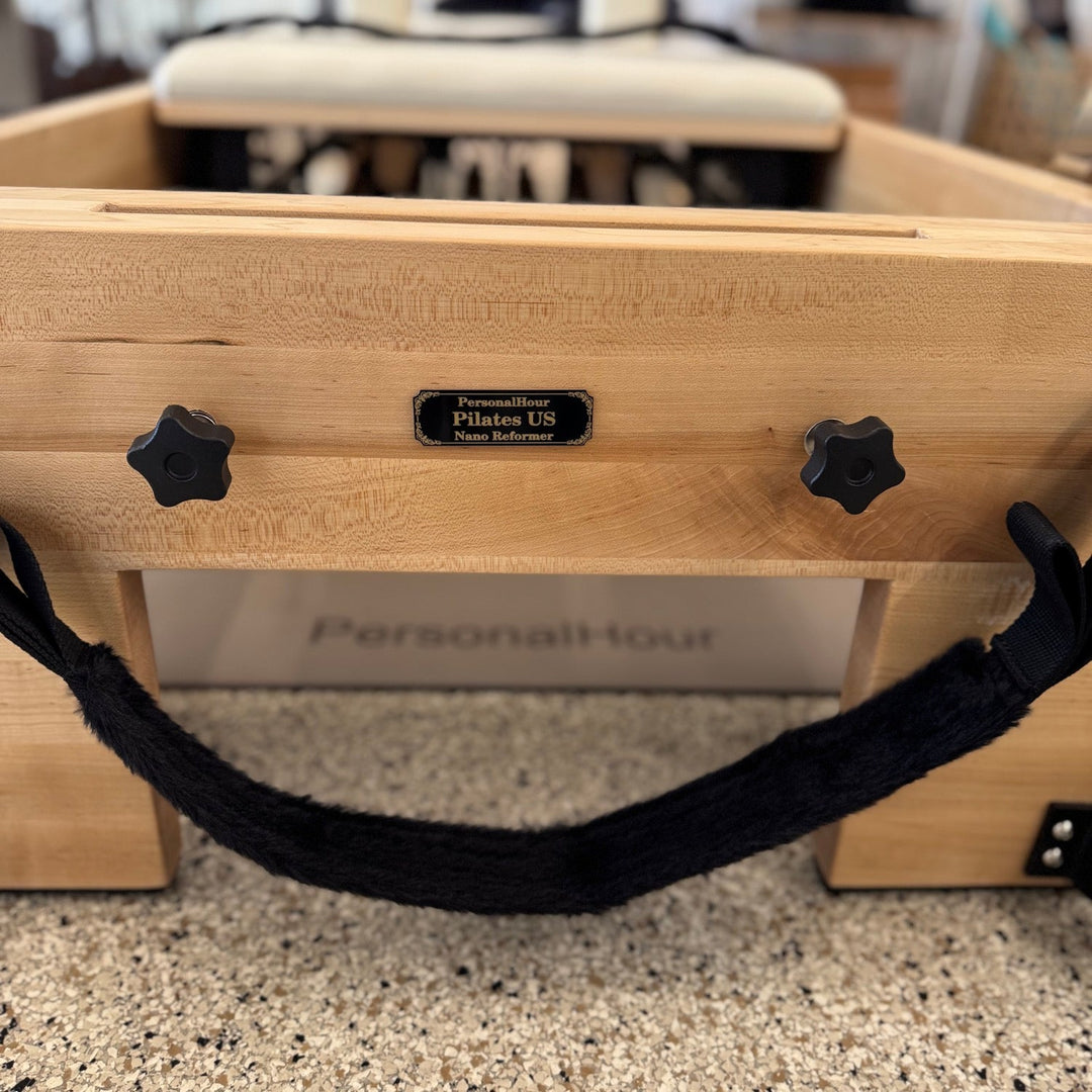 Fluffy adjustable foot strap with black star-shaped connectors on reformer