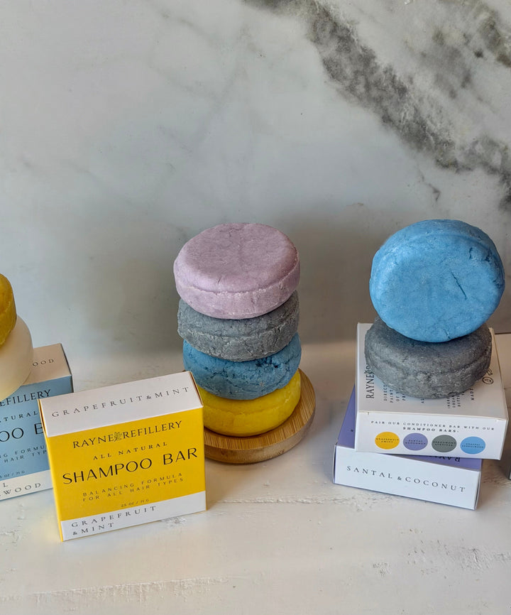 Solid shampoo bar stack in purple, blue and yellow with scent boxes