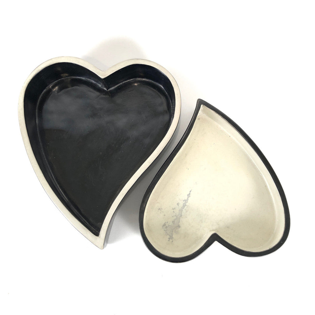 Pair of heart-shaped bowls in black and white, with raised edges and white trim