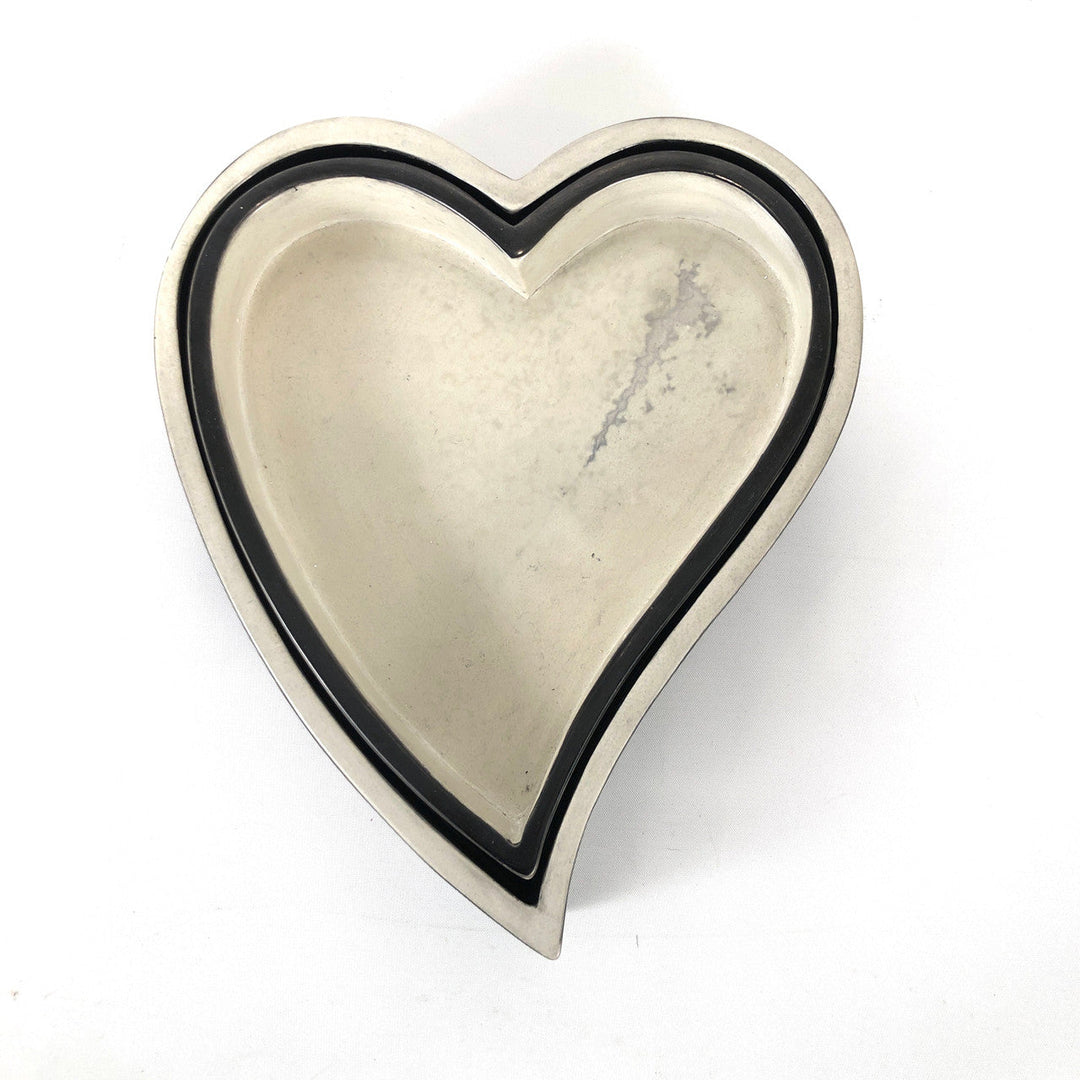 White heart-shaped bowl with black outer rim and smooth interior surface