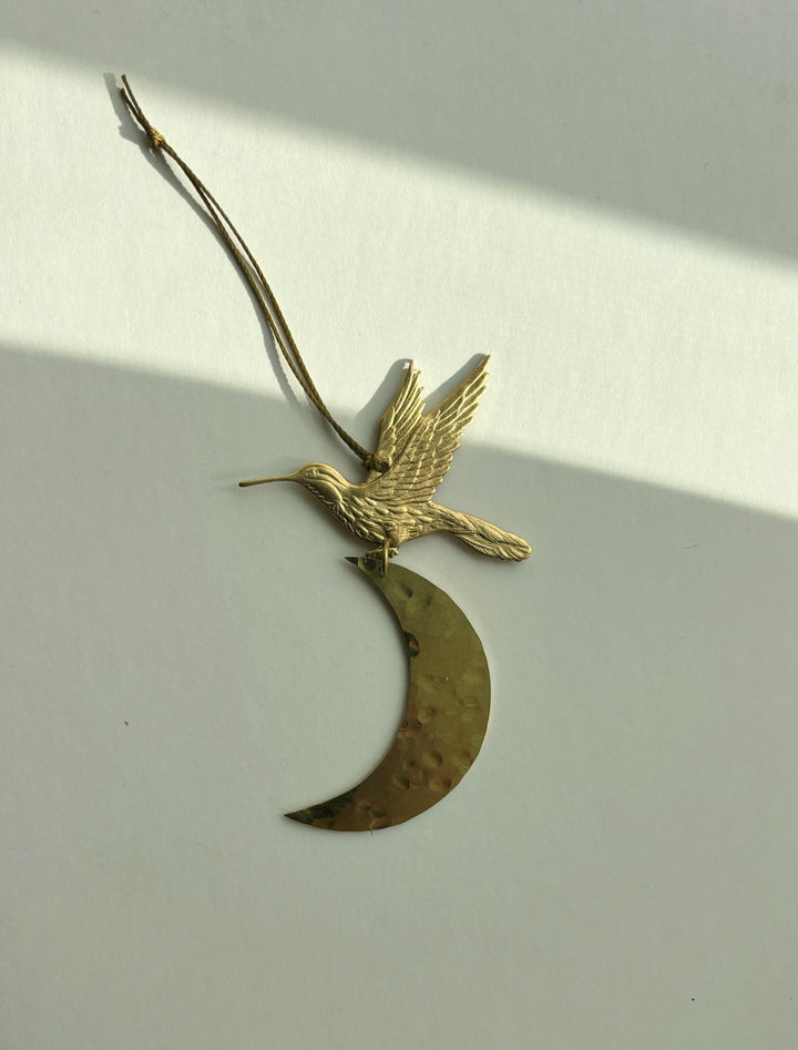 Gold bird and crescent moon ornament with hanging twine loop, side view
