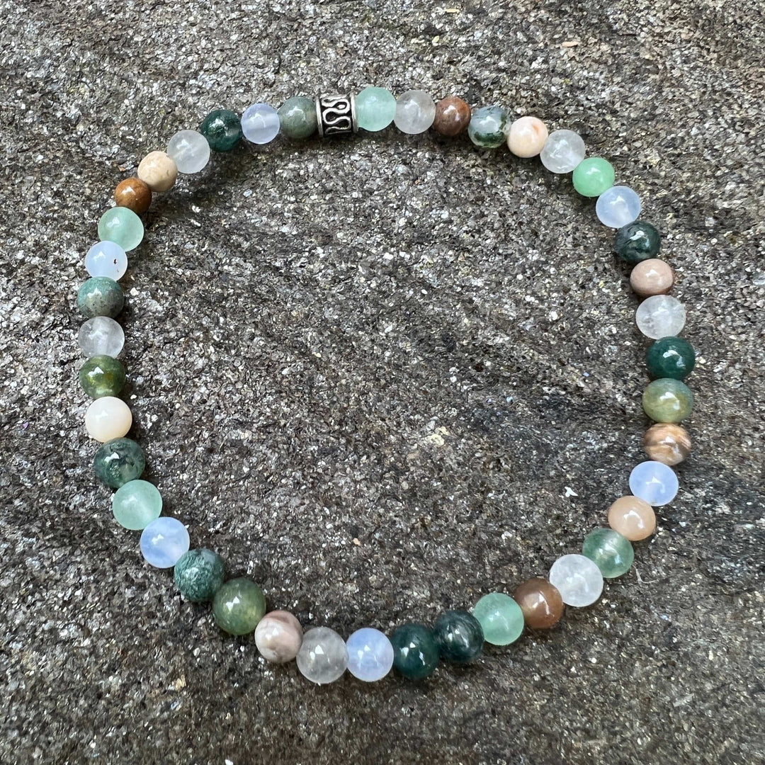 Mini beaded bracelet with round green, pale blue, and cream beads; silver clasp.