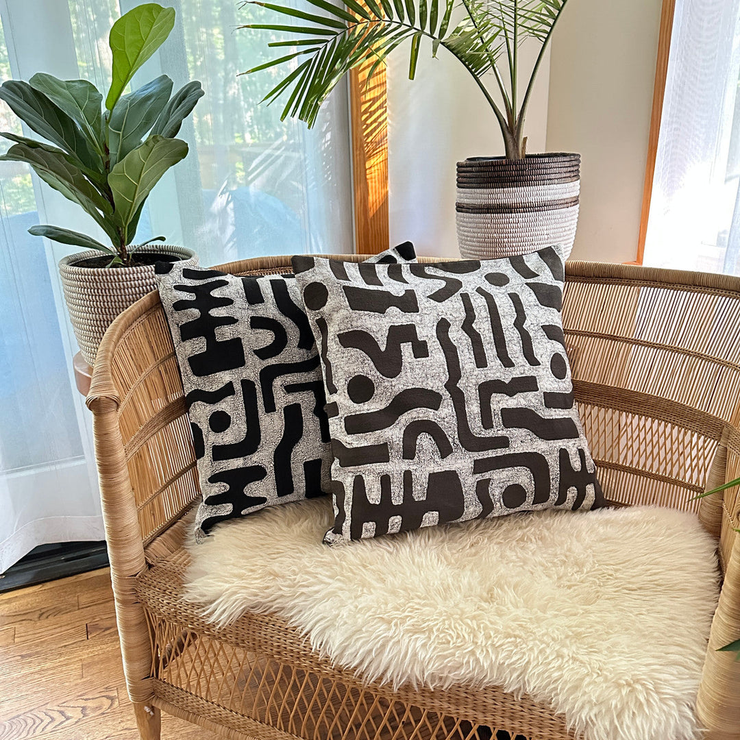 Black-and-white bogo marks pillow cover on rattan chair cushion