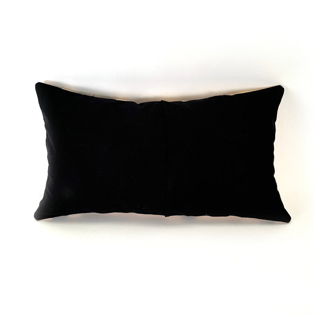 Rectangular pillow cover in solid black fabric with a sewn center seam