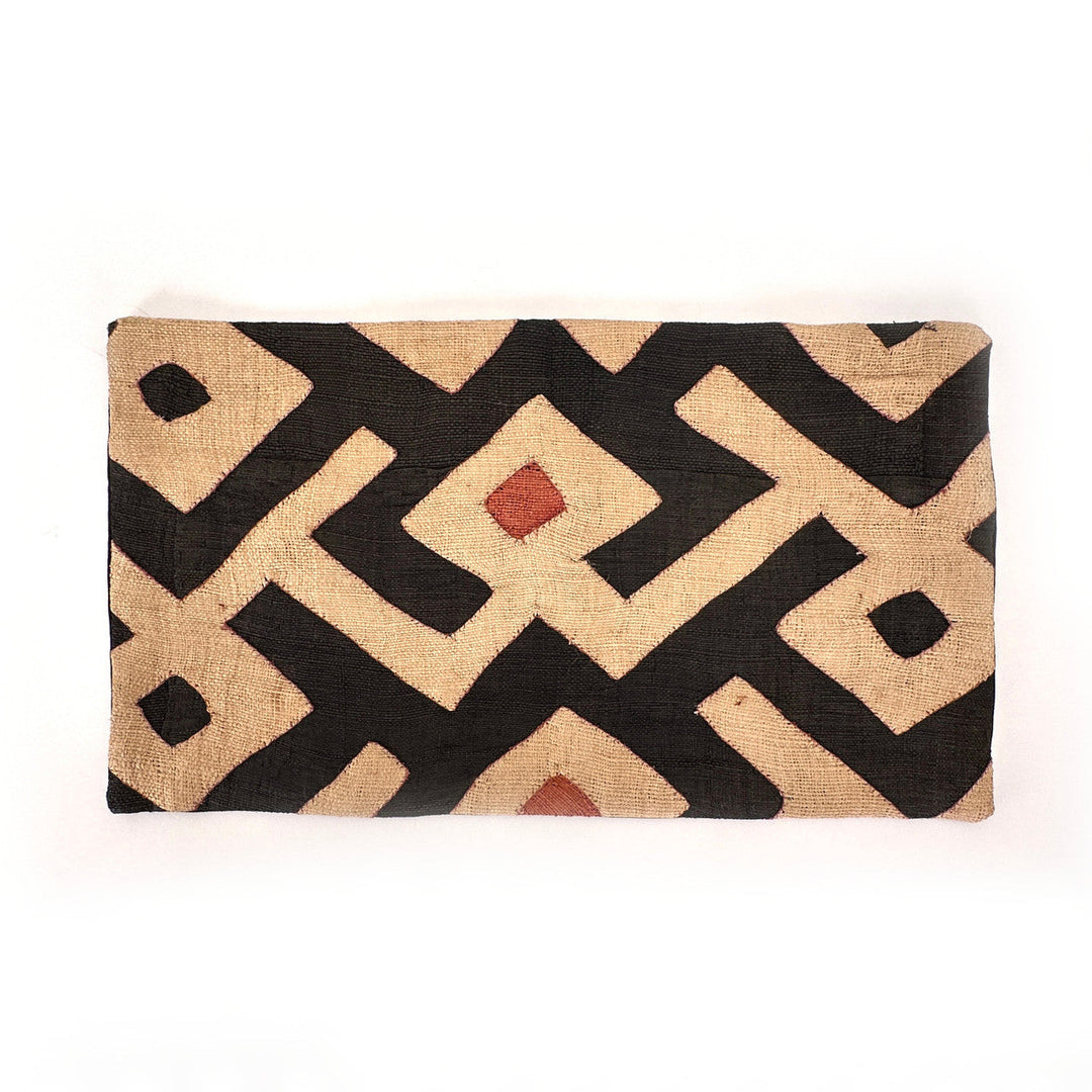 Rectangular Kuba cloth pillow cover with black and tan diamond motif and small red accents