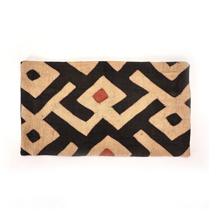 Rectangular Kuba cloth pillow cover with black and tan diamond motif and small red accents