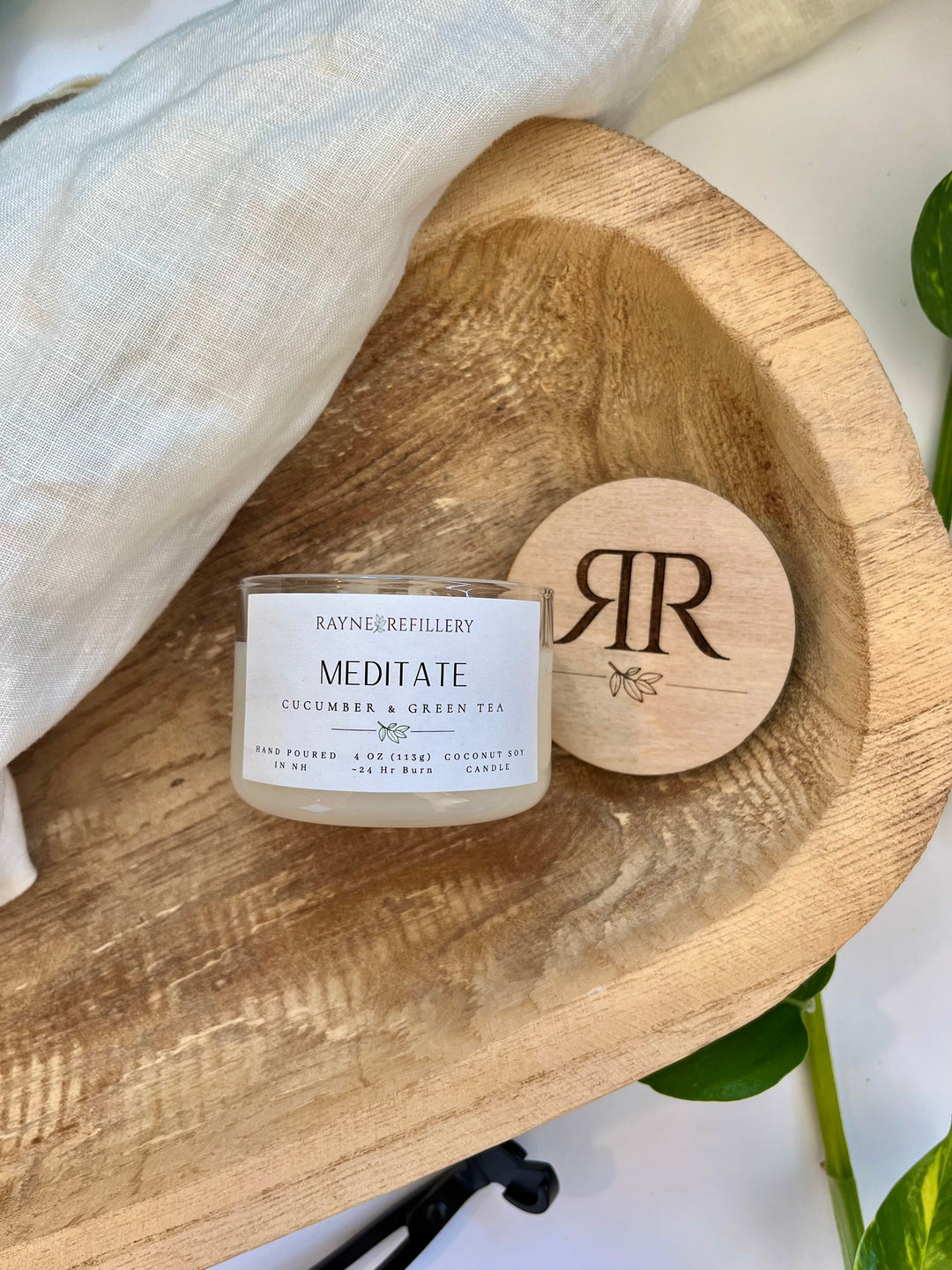 Coconut soy candle in white glass jar with wood lid, printed label visible