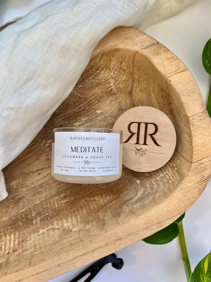 Coconut soy candle in white glass jar with wood lid, printed label visible
