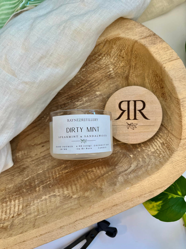 Coconut soy wax candle in clear glass jar with wooden lid, close-up of label
