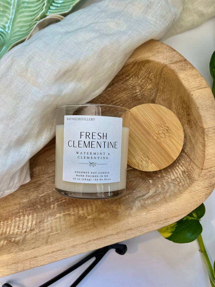Coconut soy candle with Fresh Clementine label and light wooden lid on wooden tray
