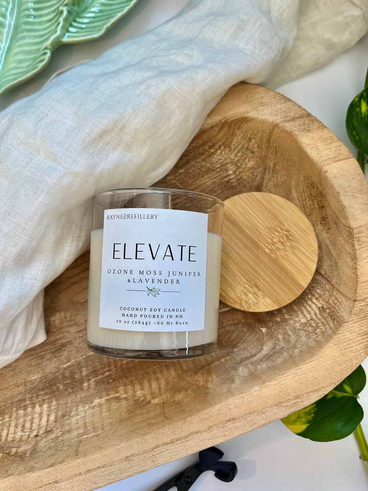 Coconut soy candle in clear glass jar with wooden heart lid on wooden tray