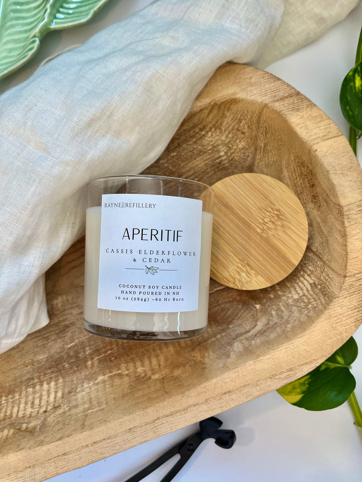 White coconut soy candle jar with wooden lid on round wood tray, printed label