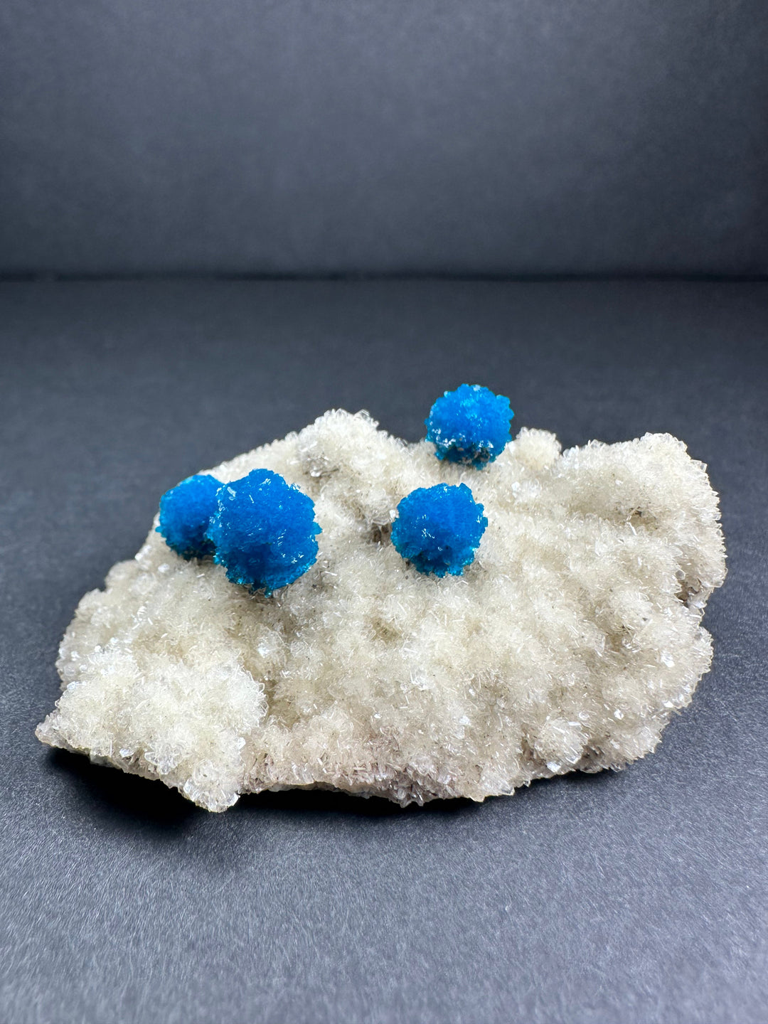White stilbite matrix with three bright blue cavansite clusters, mineral