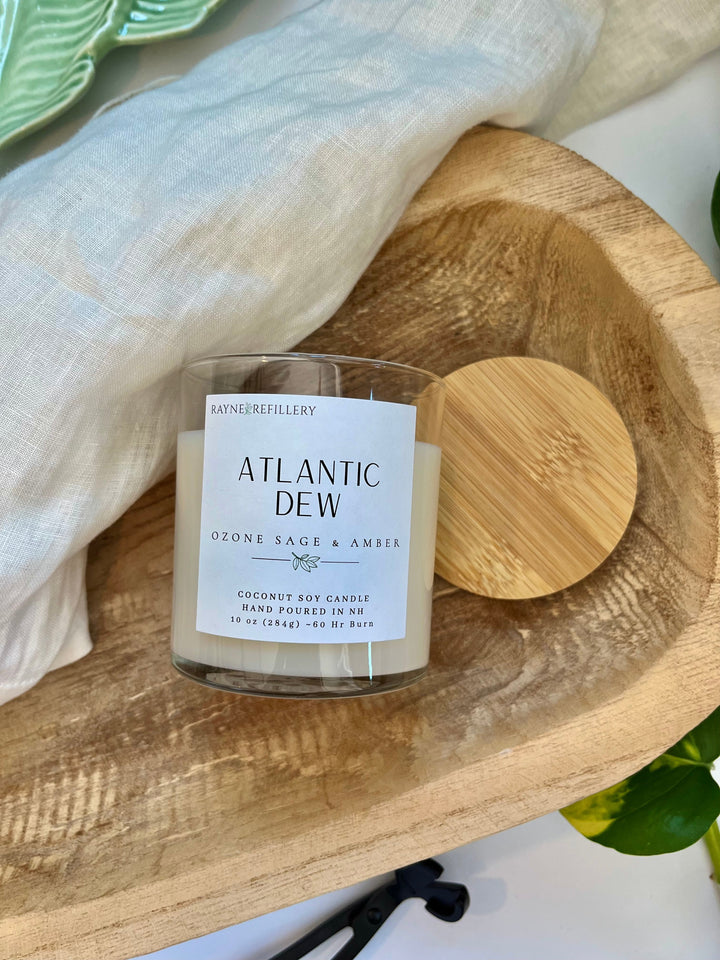 Coconut soy wax candle in white jar with wooden lid on a wooden tray