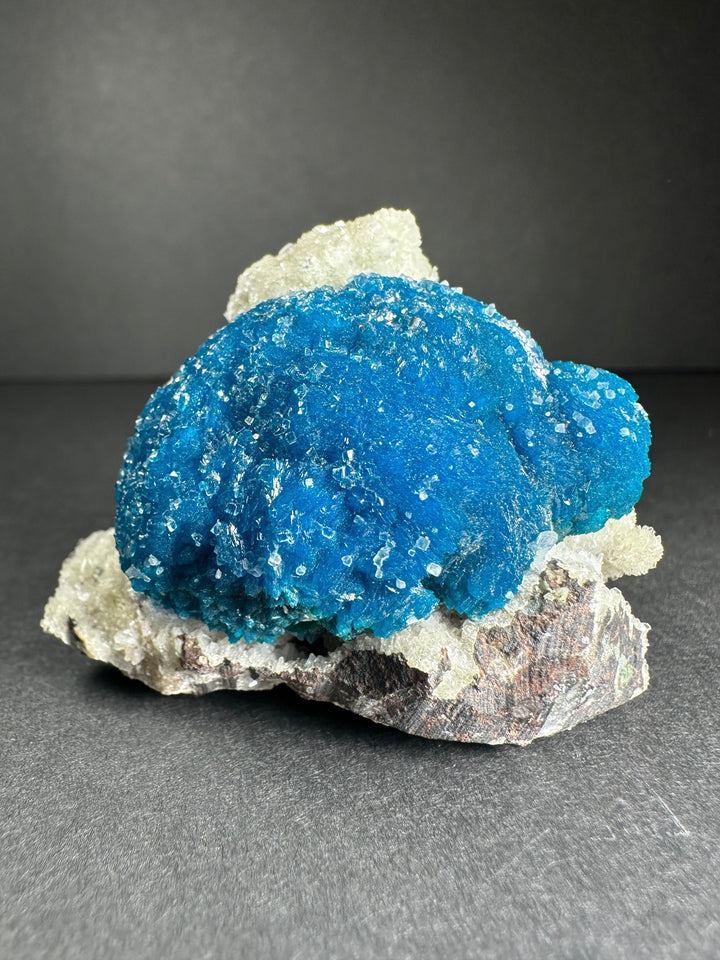 Blue cavansite with stilbite on dark rock matrix, mineral crystal cluster