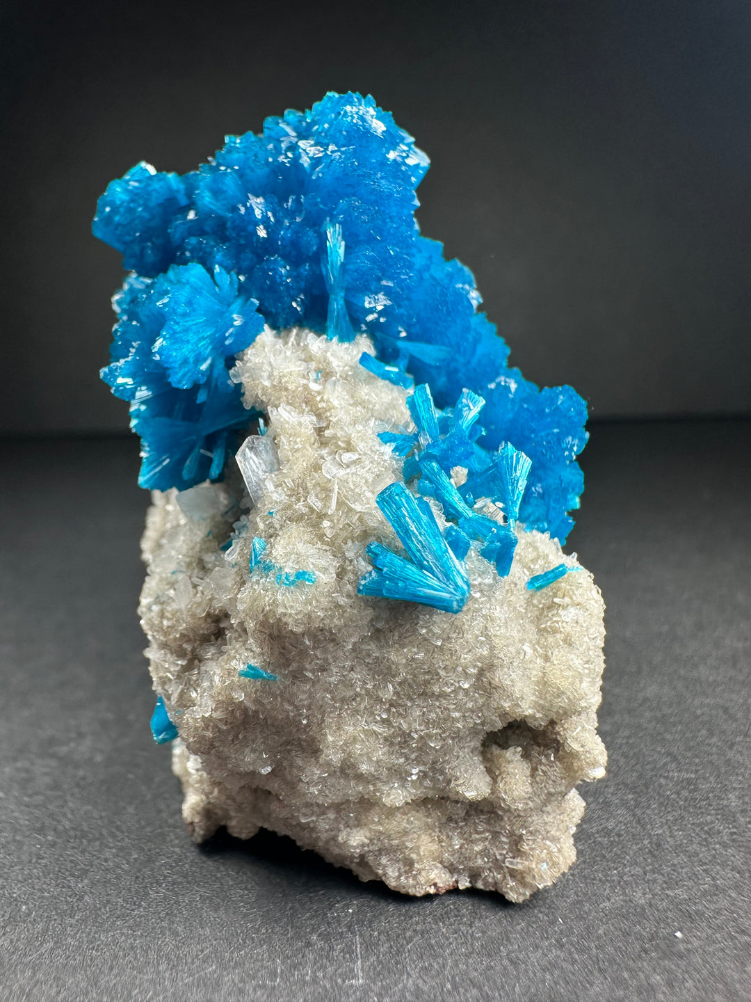 Bright blue cavansite over pale stilbite on gray rock matrix