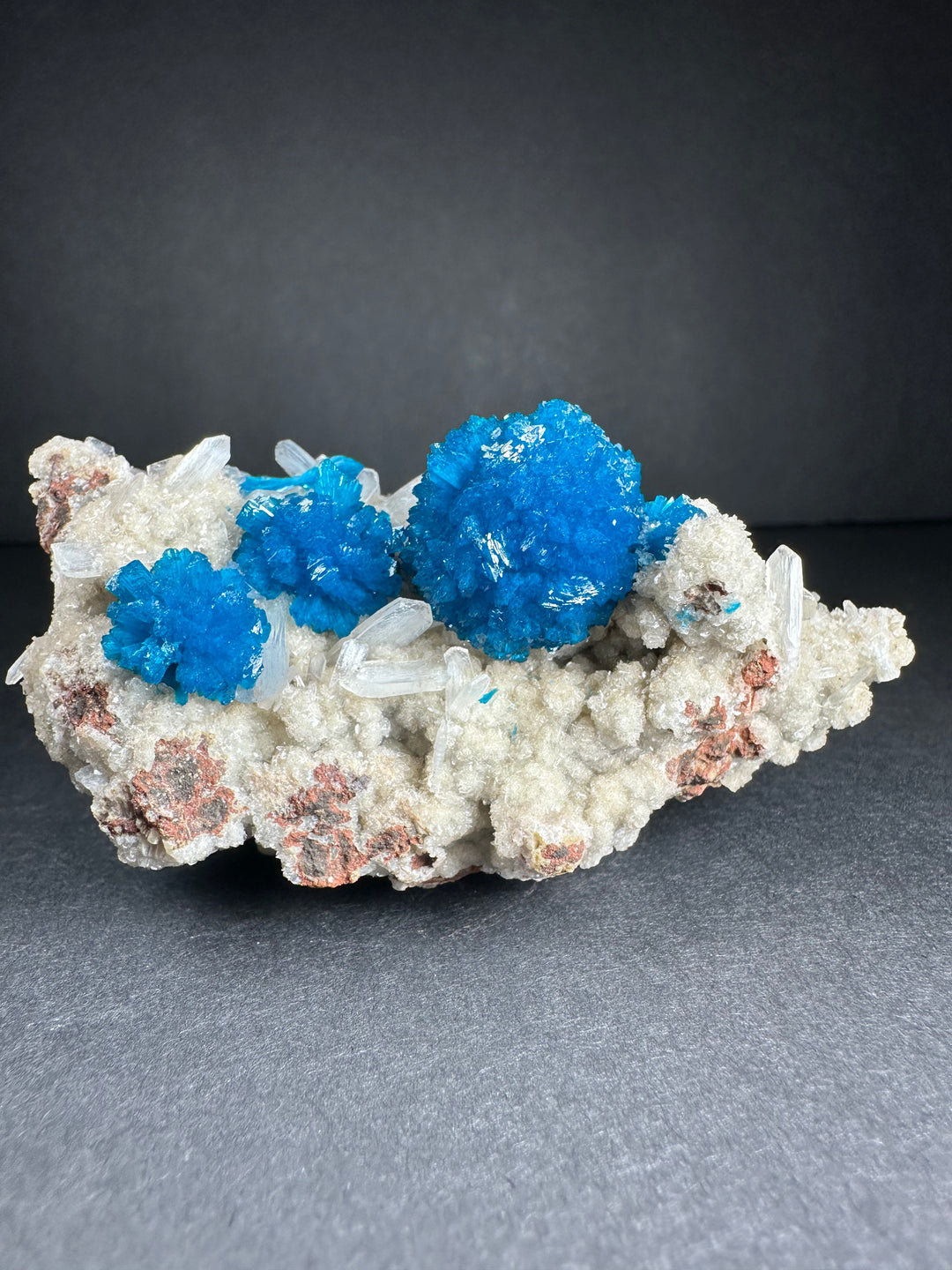Cavansite and stilbite mineral specimen on matrix with bright blue crystal clusters