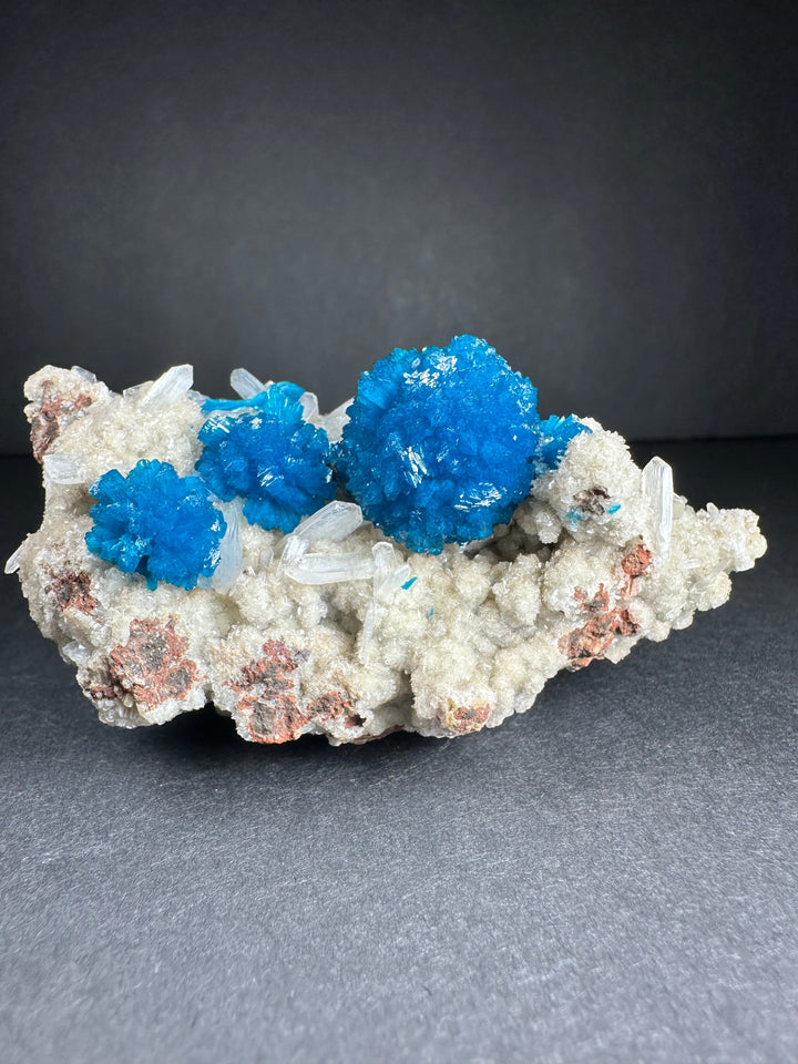Cavansite and stilbite mineral specimen on matrix with bright blue crystal clusters