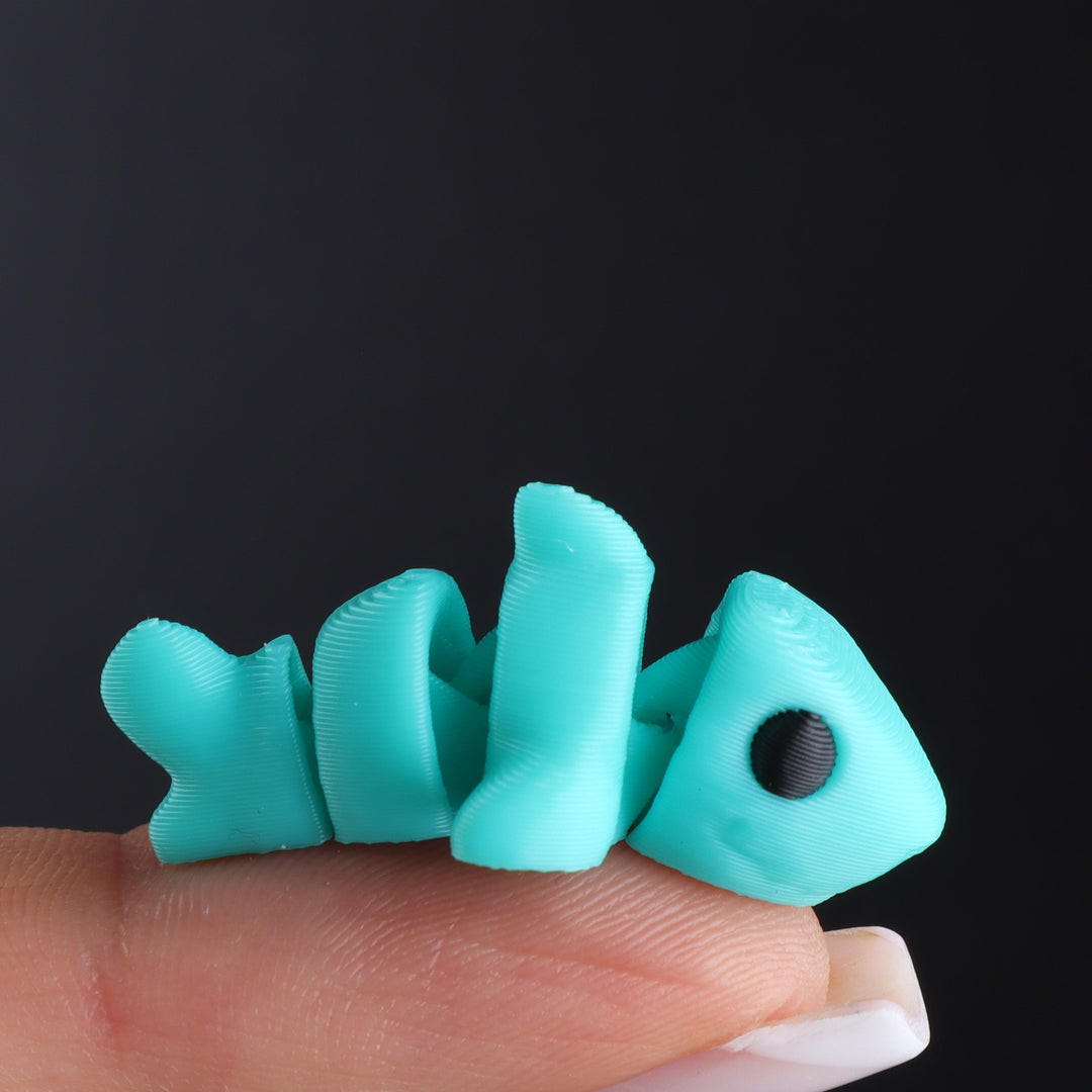 Teal animal fidget toy with black oval eye and curled tail segments