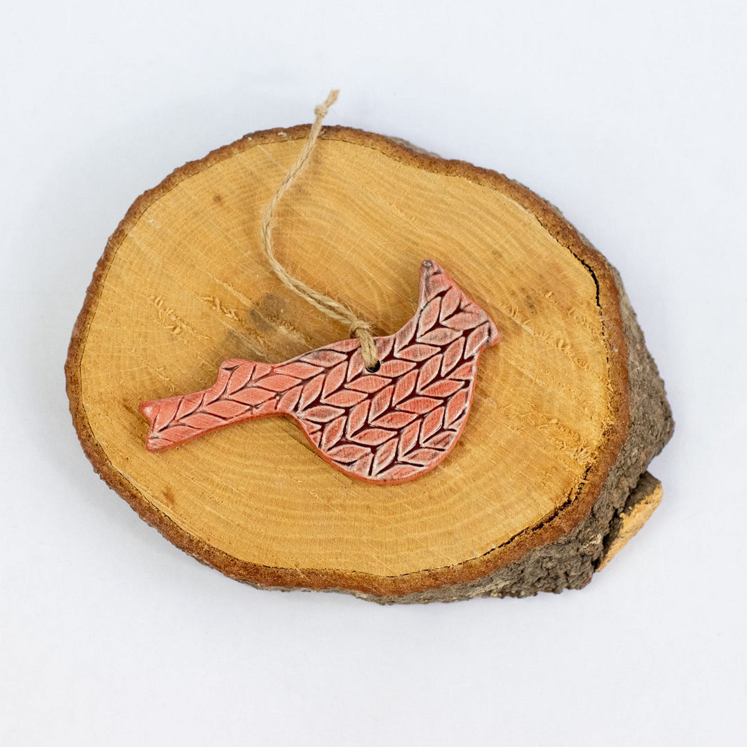 Ceramic cardinal ornament with red patterned bird on wooden slice base and hanging twine